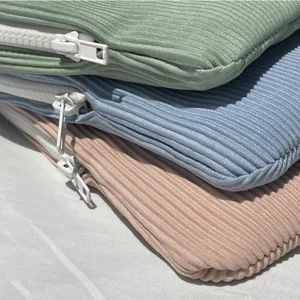 Corduroy laptop sleeve detail view, soft pastel colors and white zipper, protective ipad pouch.