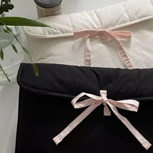 Nahaufnahme Detail der stilvollen gepolsterten Laptoptasche mit rosa Schleifen-Design.