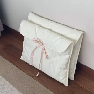 Detailaufnahme der weißen gesteppten Laptoptasche mit einer süßen rosa Schleife.