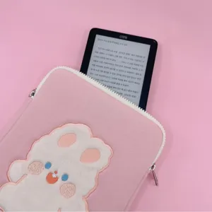 Pink tablet sleeve detail showing cute plush embroidery and secure white zipper closure.