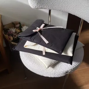Detailansicht der gesteppten Laptoptasche mit niedlicher rosa Schleife und wattiertem Design.