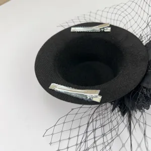 Detail view of black vintage mini top hat fascinator hair clip with mesh and feathers.
