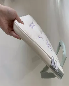 Detailansicht einer schicken bestickten Schleife Laptoptasche mit Handgriffen, weiß.