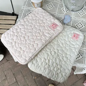 Detailed shot of Korean style quilted floral laptop sleeve, soft bubble cotton tablet pouch.