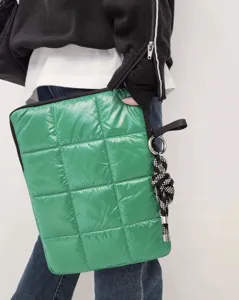 Vista dettagliata della custodia per laptop verde brillante con ciondolo a nodo in corda.