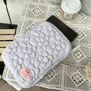 Quilted floral tablet sleeve detail shot, cute flower pattern padded laptop pouch interior view.