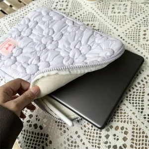 Detailed shot of purple quilted floral tablet sleeve case with soft inner lining and zipper.