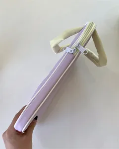 Hübsches pastellfarbenes Laptoptaschen-Detail mit Doppelreißverschluss und weichen Griffen.