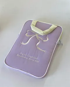 Lila Laptop-Haeulle Detail mit gestickter Schleife und hellem Griff fuer Tablets und Notebooks.