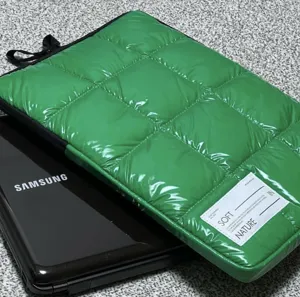 Custodia per laptop trapuntata verde in stile piumino, morbida borsa protettiva.