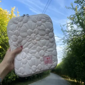 Quilted flower detail on soft pink laptop sleeve, cozy texture close-up for daily protection.