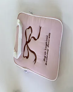 Detailansicht der rosa Laptoptasche mit süßer brauner Schleifenstickerei und Text.