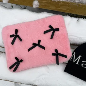 Pink furry laptop sleeve detail featuring cute black ribbon bows, soft plush texture design.