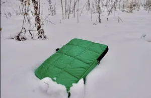 Vista dettagliata di una custodia per laptop trapuntata verde sulla neve.