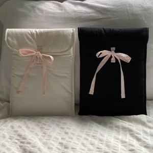 Nahaufnahme der gesteppten Laptoptasche mit rosa Schleife, weiche ästhetische Tabletttasche.