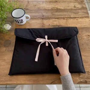 Detailansicht der schwarzen gesteppten Laptoptasche mit süßer rosa Schleife, weicher Schutz