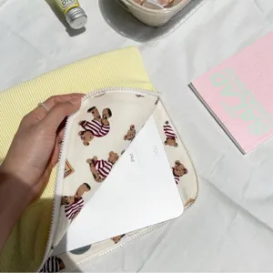 Detailed close-up view of yellow corduroy tablet sleeve featuring cute bear lining and zipper.