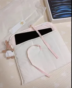 Gesteppte rosa Tablettasche mit süßen Schleifen und Plüschhasen-Anhänger, weich.