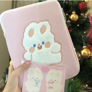 Detailed view of the cute pink laptop sleeve featuring fluffy white rabbit embroidery design.