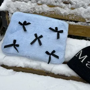 Fluffy blue laptop sleeve with cute black bows, soft plush interior, winter aesthetic design.