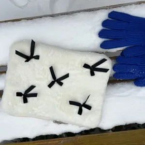 Fluffy laptop sleeve detail showing soft white plush texture and elegant black bow ribbon accents.