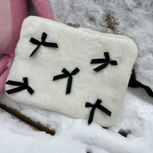 Cute white plush laptop sleeve with black bows, soft fuzzy computer storage bag for women.