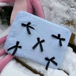 Detail view of cute light blue plush laptop sleeve decorated with stylish black ribbon bows.