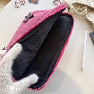 Pink plush laptop sleeve with cute bow and black inner lining for notebook protection.