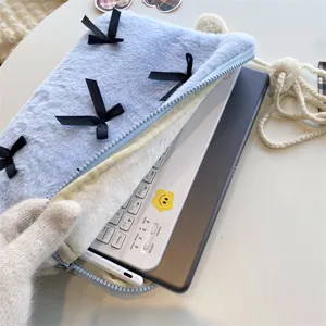 Plush laptop sleeve with cute black bows detail shot showing soft interior storage capacity.