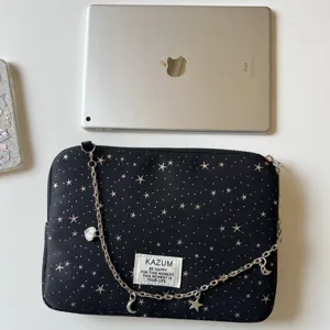 Black star print laptop sleeve with chain strap and cute charms for iPad and notebook storage.