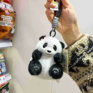 Nahaufnahme des süßen Panda Plüschschlüsselanhängers mit schwarz-weißen Details und Schleife.