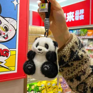 Detailaufnahme des niedlichen Plüsch-Panda-Schlüsselanhängers mit weichem Stoff und Stickerei.