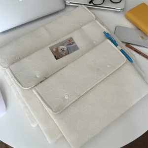 Gesteppte Laptoptasche mit Herzmuster und Tablet-Schutzhuelle in cremeweisser Farbe.