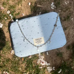Light blue aesthetic laptop tablet sleeve bag with silver star pattern and chain strap charm details.