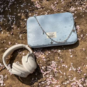 Light blue star pattern laptop sleeve with metal chain strap and decorative woven label.