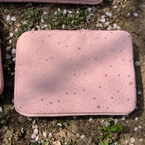 Pink laptop sleeve detail showcasing silver stars pattern and convenient zipper closure.