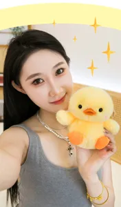 Cute yellow chick plush toy detail view, soft stuffed animal doll for desktop decor.
