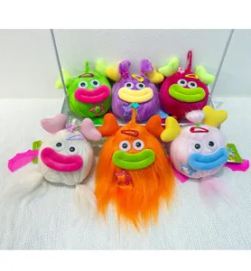 Close-up detail of colorful funny long-haired big mouth plush monster pendant keychain accessories.