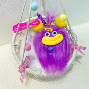 Cute fluffy big mouth monster plush pendant keychain toy displayed in a woven hanging basket.