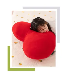 Primo piano dettagliato di un morbido cuscino di peluche rosso a forma di cuore, decoro.