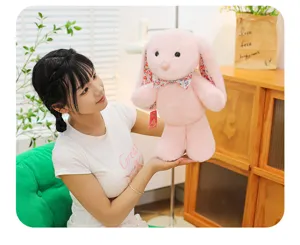 Detailed closeup view of a cute pink plush rabbit toy featuring charming floral ears held by a model.