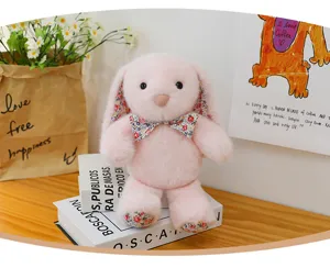 Cute pink plush lop-eared bunny doll with floral ears and bow, perfect home decor gift.