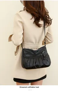 Detailed view of a fashionable black shoulder crossbody bag with multi-zipper design.