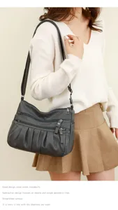 Detail view of the dark grey soft leather multi-pocket shoulder and crossbody bag.