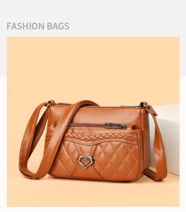 Detail shot of retro brown leather crossbody bag with quilted pattern and cute heart metal lock.