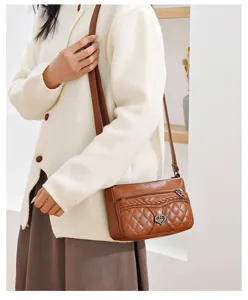 Brown quilted leather crossbody bag detail, vintage shoulder handbag with heart pendant.