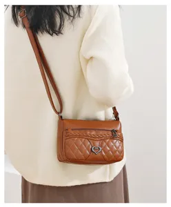 Detail view of brown quilted leather crossbody bag, casual small phone purse with heart decor.