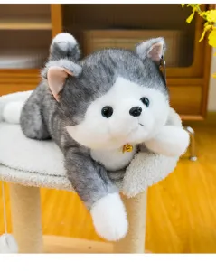 Cute grey and white lying cat plush toy stuffed animal with small golden bell detail.