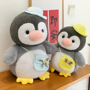 Charmantes Plüsch Pinguin Spielzeug Set mit karierten Hüten und Taschen als Dekoration.