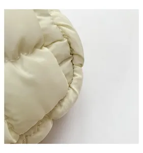 Close-up view of the cream white quilted puffer crossbody bag showcasing fine stitching detail.